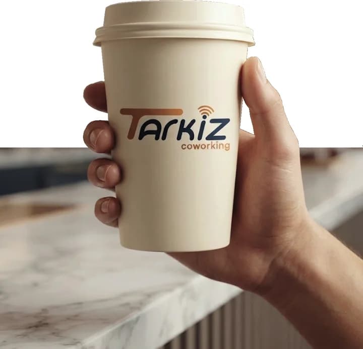 Un gobelet de café Tarkiz tenu près d’une fenêtre